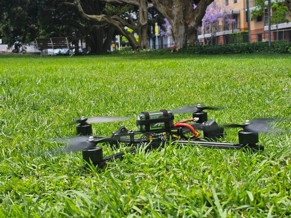 The ADA2M quadcopter on grass during outdoor testing.