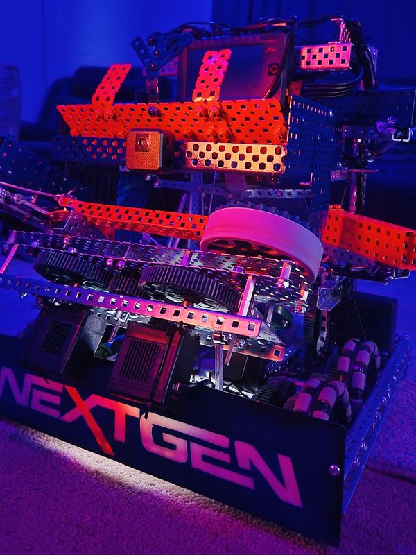 The Spin Up season robot lit with red and blue light, showing the flywheel, the gear train and the NextGen name plate.